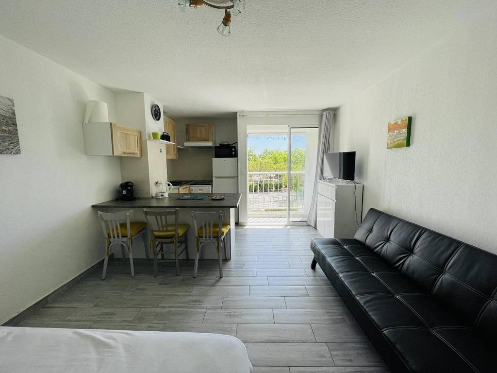 un salon avec un canapé et une cuisine dans l'établissement Studio rénové, calme, proche plage et commodités, parking inclus - FR-1-723-105, au Cap d'Agde