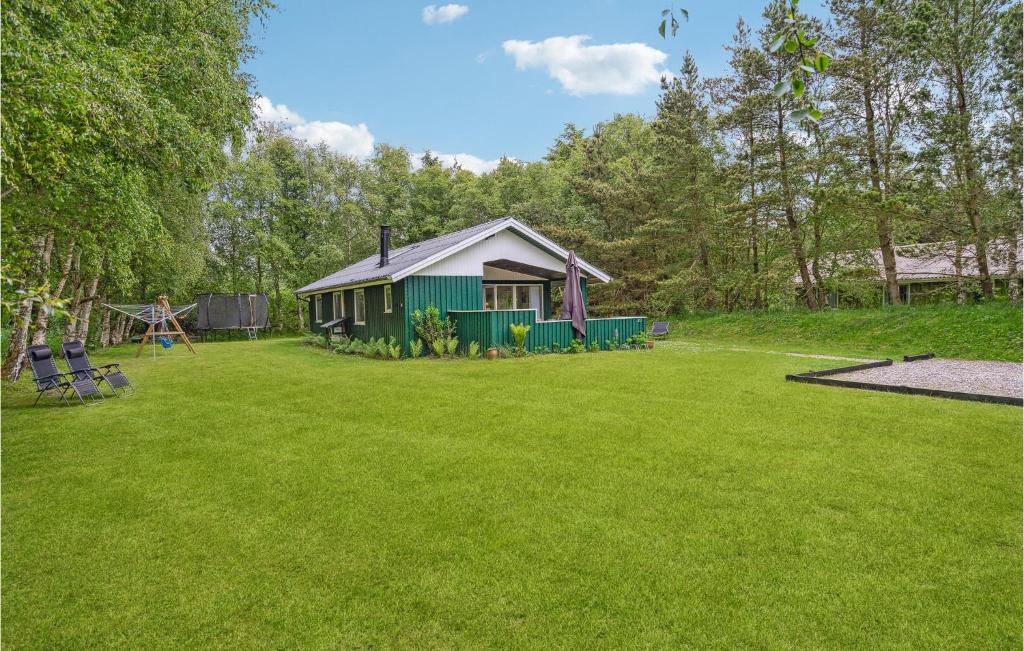 eine kleine grüne Hütte in einem Hof mit Spielplatz in der Unterkunft Amazing Home In Brovst With Kitchen in Brovst