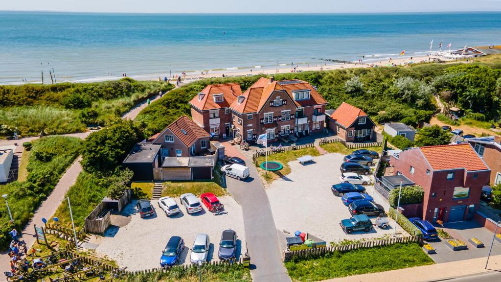 an aerial view of a house with a lot of parked cars at Duinhotel Haga in Zoutelande