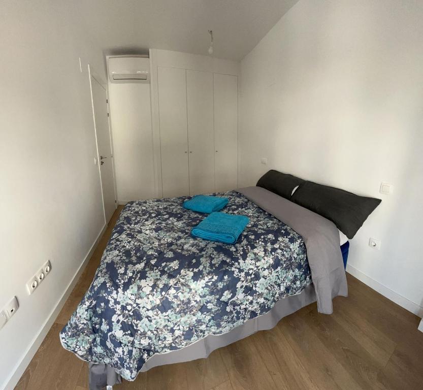 ein kleines Schlafzimmer mit einem Bett mit blauer Bettwäsche in der Unterkunft Mars Suites Porras in Madrid