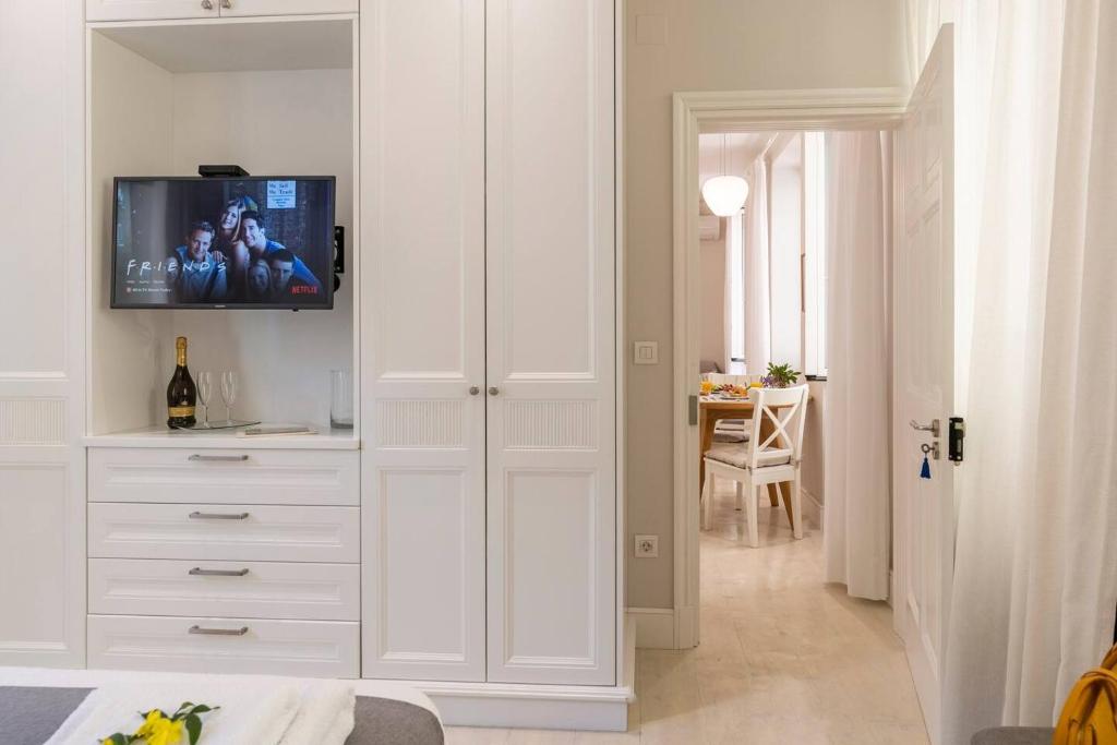 sypialnia z białą szafką z telewizorem w obiekcie Palazzino Leone - Corfu Old Town Liston Deluxe Apartment w Korfu