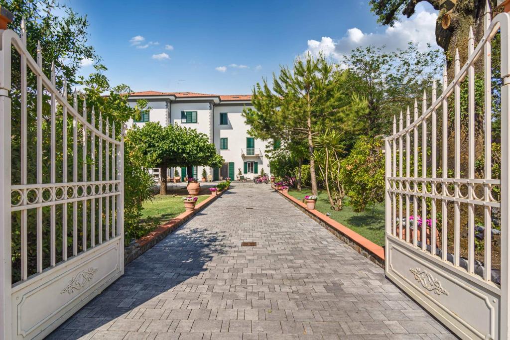 a cobblestone street with a white fence and a building at Hotel Bellonda in Forte dei Marmi