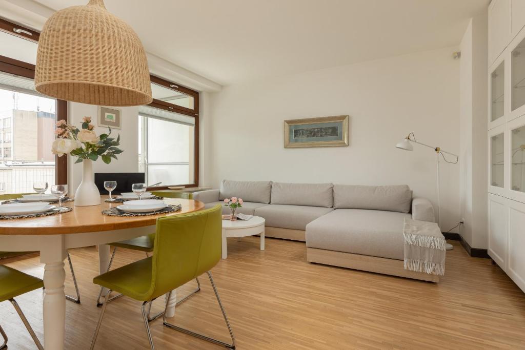 a living room with a table and a couch at Royal Park Łazienki Apartment Warsaw Mokotów by Renters in Warsaw