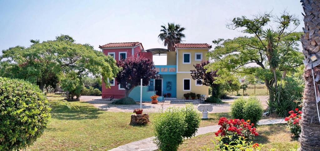 a house in a park with trees and flowers at Heliatoras Studios in Loutrópolis Thermís