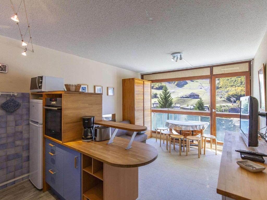une cuisine avec une table et une salle à manger avec vue dans l'établissement Studio cabine 6 personnes au pied des pistes à Gourette, séjour avec balcon, parking - FR-1-400-117, à Eaux-Bonnes