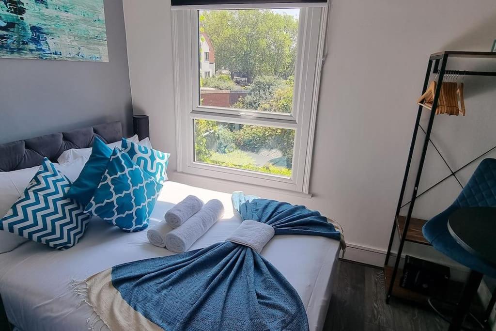 a bed with pillows and a window in a room at Contemporary Studio Haven l 1Bed 1 Bath in London in London