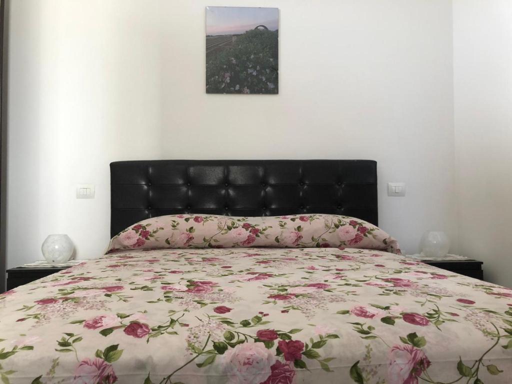 una camera da letto con un letto con copriletto floreale di Casa La Noria a Mola di Bari