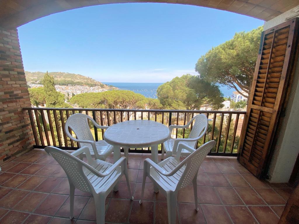 a patio with a table and chairs on a balcony at Apartamento con espectaculares vistas al Mediterráneo in Calella de Palafrugell