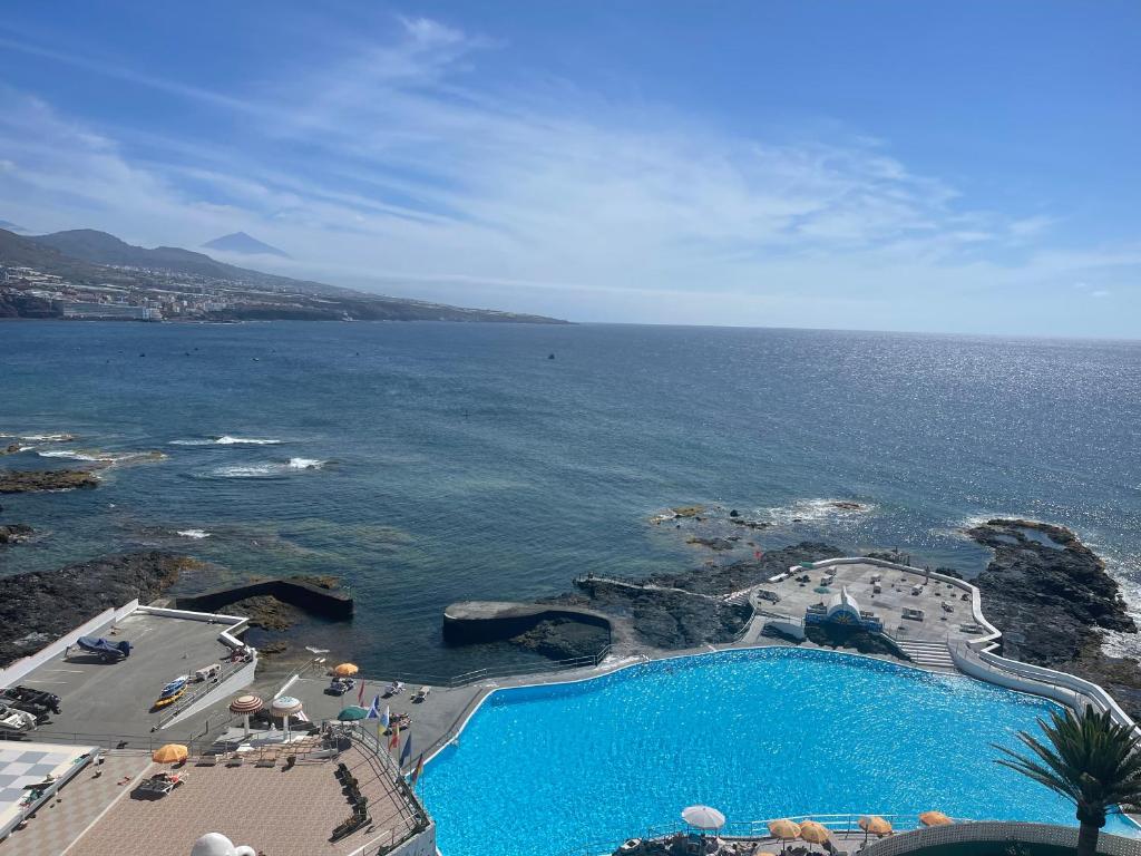 vista aerea su una piscina vicino all'oceano di Apartamento vacacional Altagay a Punta del Hidalgo