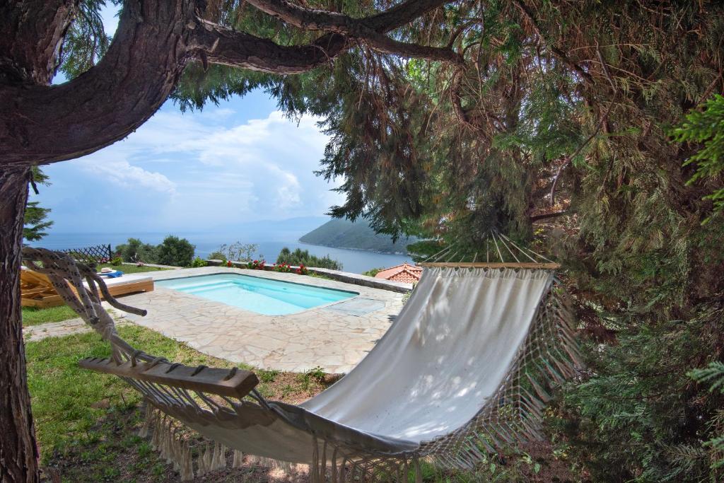 a hammock hanging from a tree next to a swimming pool at Petra Mare Village in Kerveli
