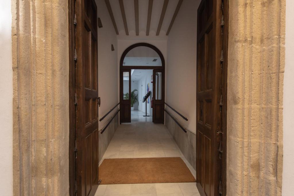 un pasillo con puertas de madera y un arco en Apartamentos Santa María 15, en Jerez de la Frontera