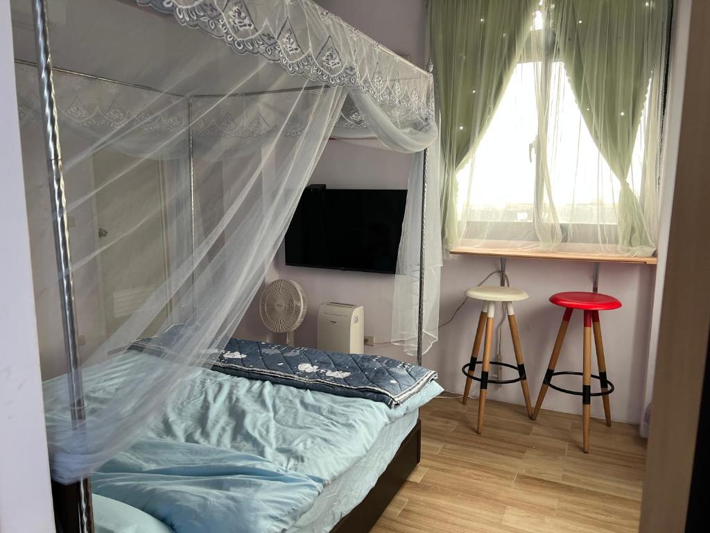 莒光鄉的住宿－台北人民宿，一间卧室配有一张带天蓬和窗户的床