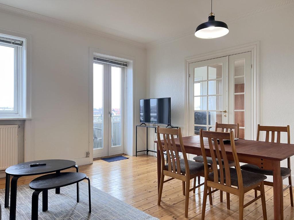 ein Esszimmer mit einem Tisch, Stühlen und einem TV in der Unterkunft One Bedroom Apartment In Glostrup, Tranemosevej 1, in Glostrup