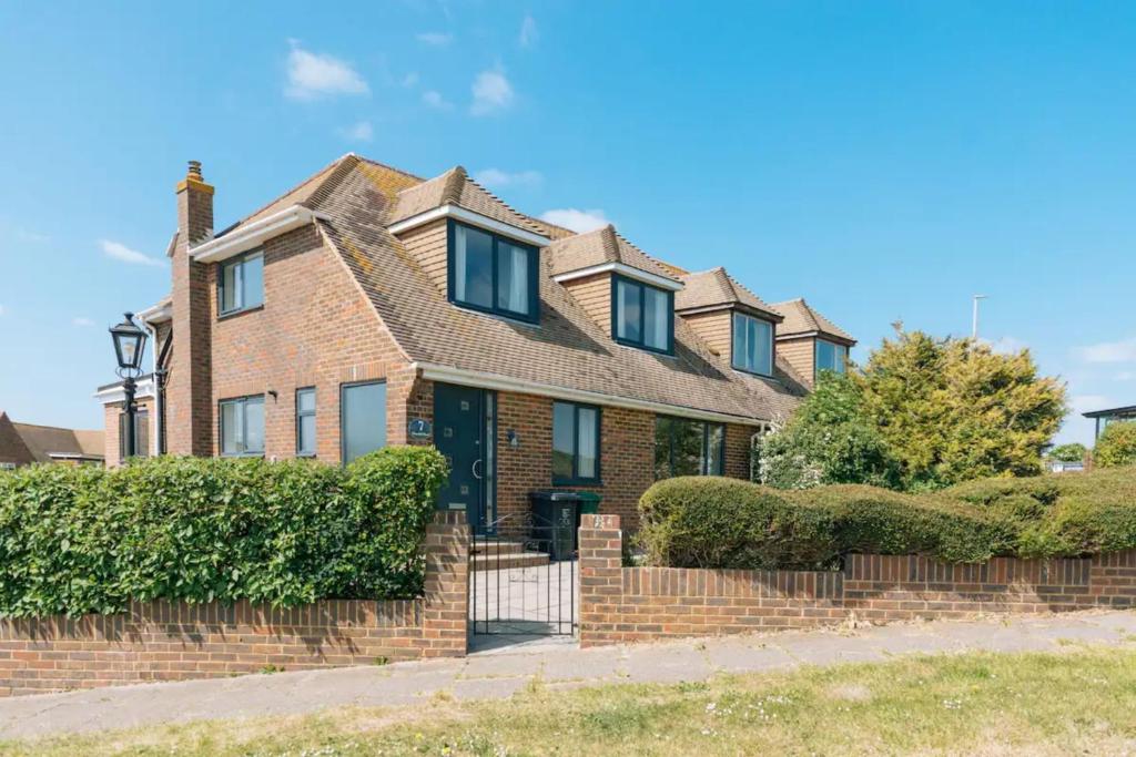 a brick house with a fence in front of it at Lush & Spacious 3BD House - East Brighton in Brighton & Hove