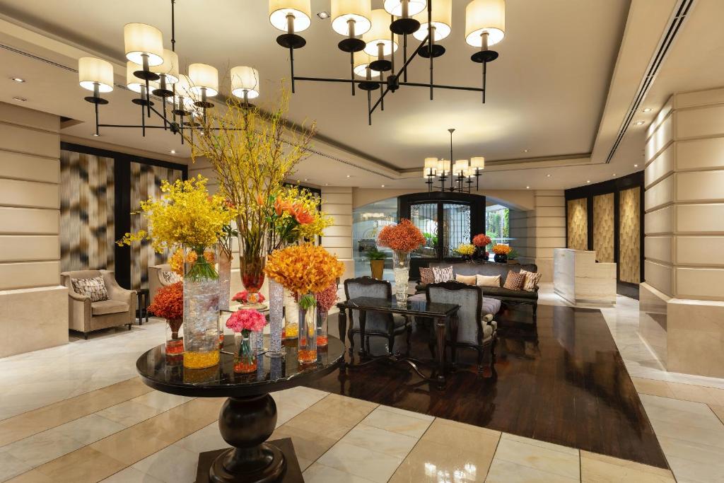 A bright hotel lobby lounge centered on a large floral arrangement.