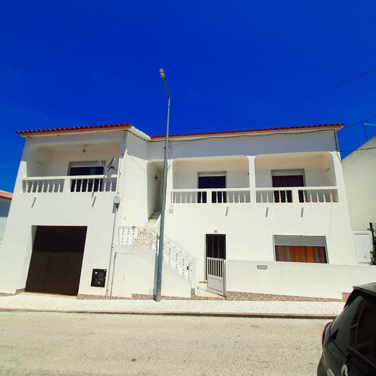 - un bâtiment blanc avec balcon dans une rue dans l'établissement Casa Rocha Relax, à Aljezur
