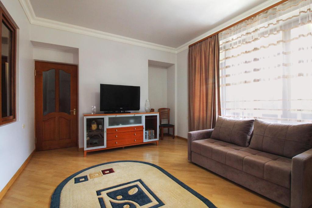 sala de estar con sofá y TV en 2 Bedroom Apartment on Tumanyan street en Ereván