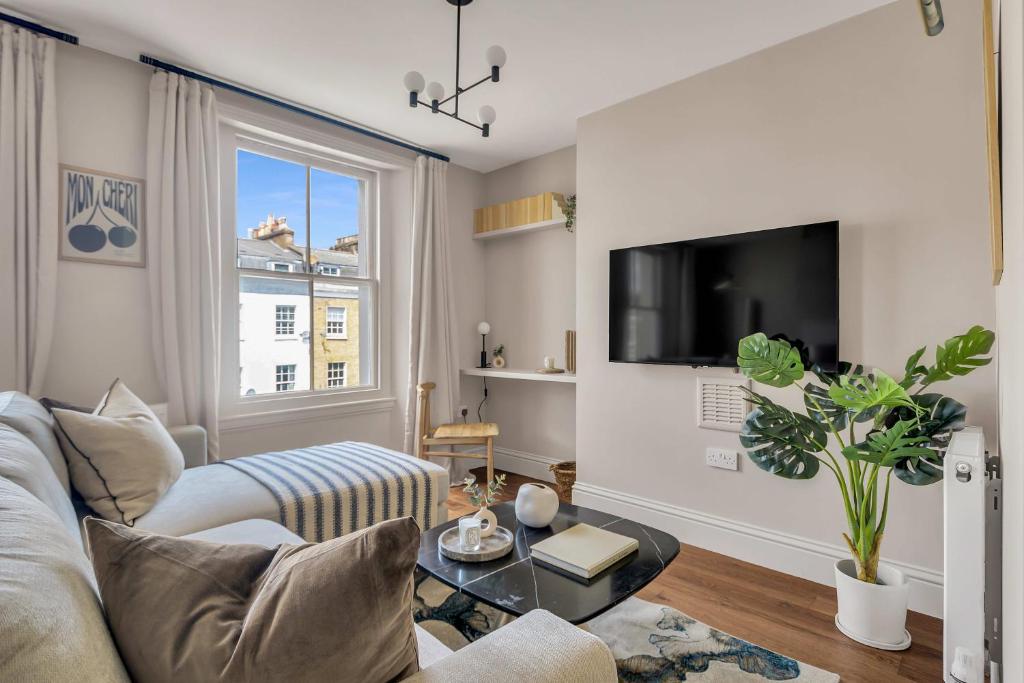 a living room with a couch and a tv at Be London - The St John's Wood Residences in London