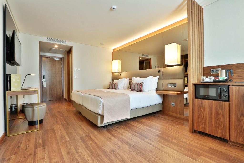 a large hotel room with a bed and a television at TURIM Ibéria Hotel in Lisbon
