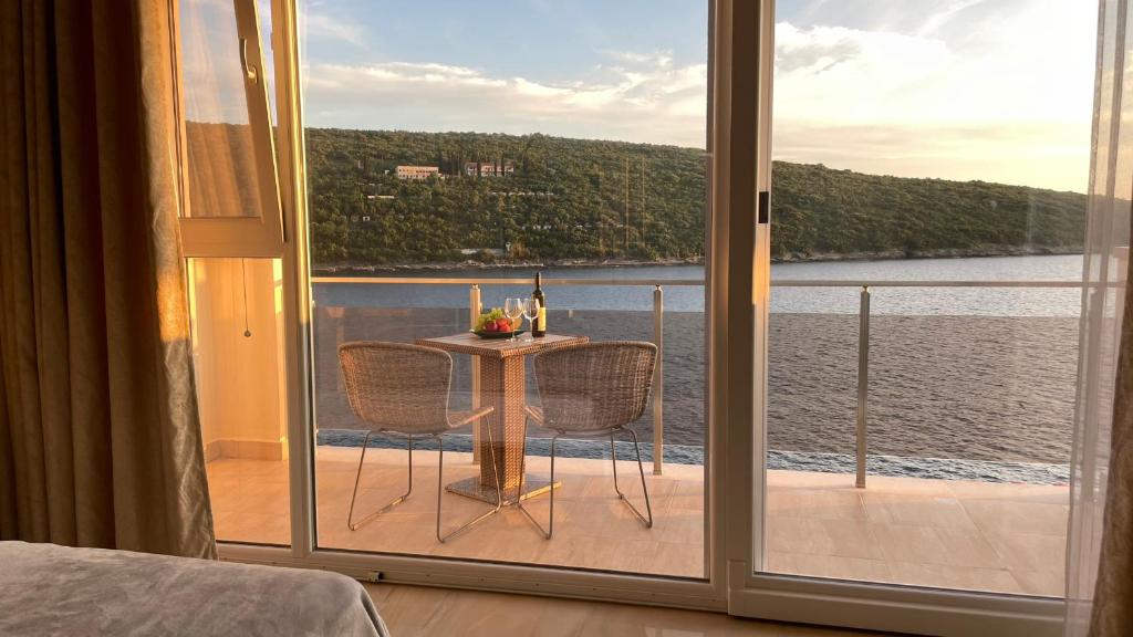 um quarto com uma mesa e vista para a água em Seafront apartments em Bigovo