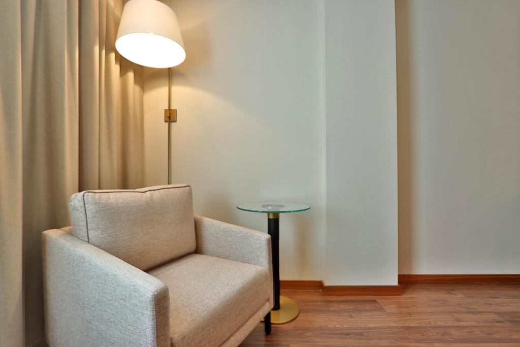 a room with a chair and a lamp and a table at TURIM Ibéria Hotel in Lisbon