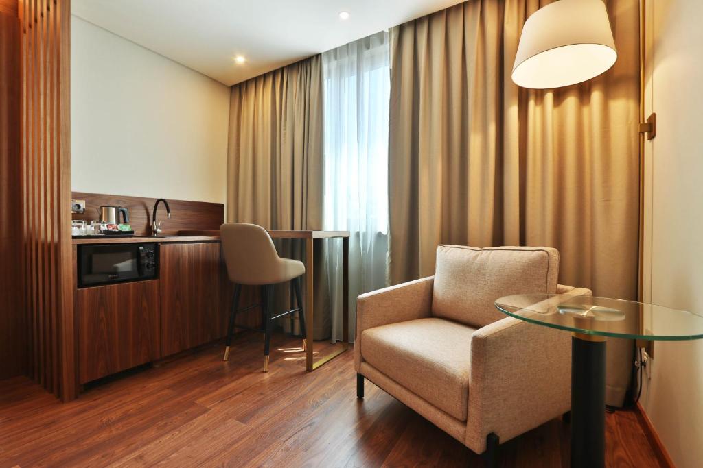 a living room with a chair and a table at TURIM Ibéria Hotel in Lisbon