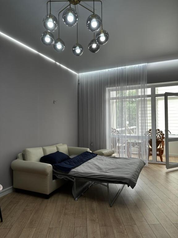 a living room with a bed and a couch at Уютная квартира в центре города in Uralsk