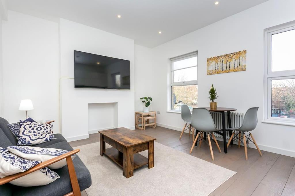 een woonkamer met een bank en een tafel bij Stunning Modern two bedroom flat near Notting hill Gate in Londen