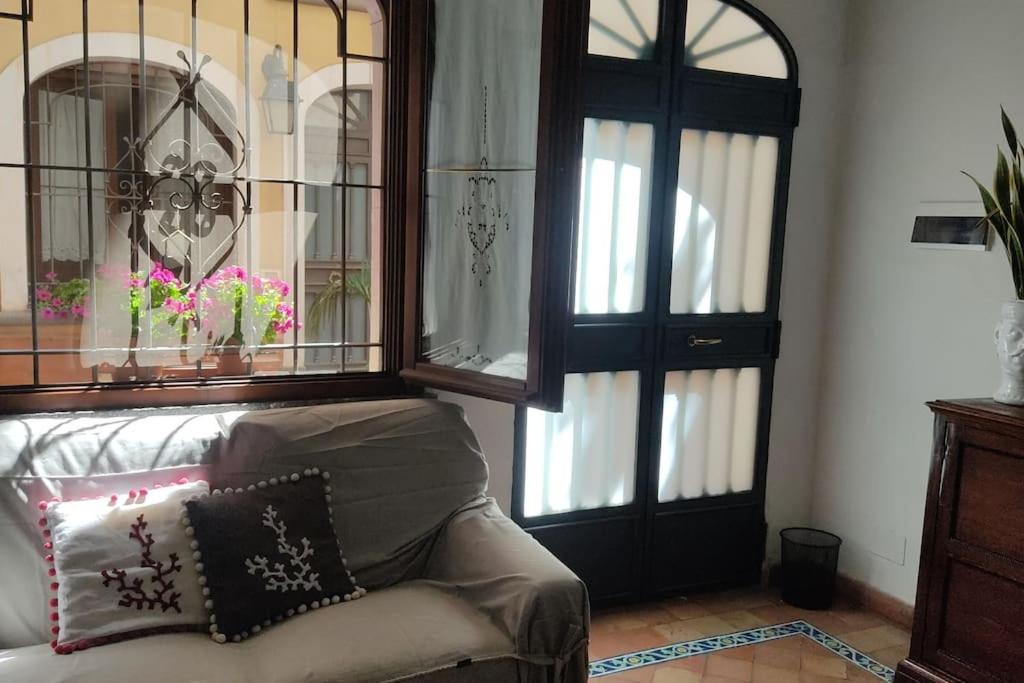 een woonkamer met een bank en twee glazen deuren bij La Casa di Clo in Catania