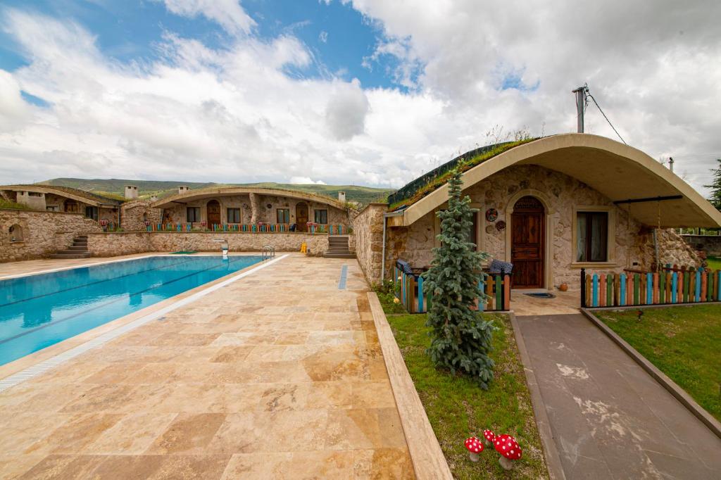 a house with a swimming pool next to a building at Cappadocia Hobbit House in Nevşehir