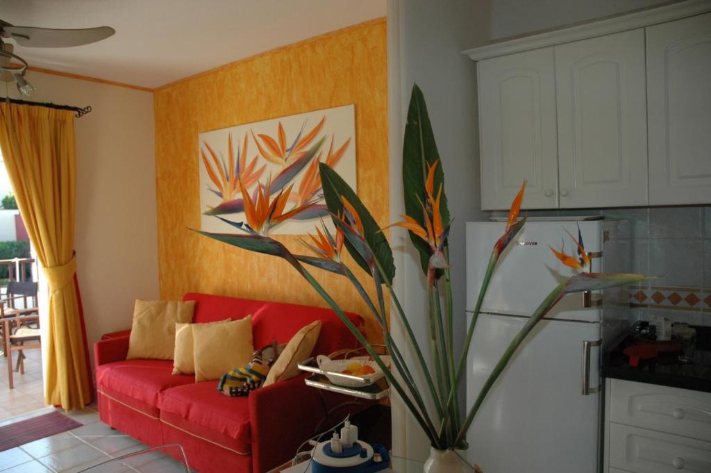 a living room with a red couch and a plant at Penthouse El Mirador Los Cristianos Tenerife - VV in Los Cristianos