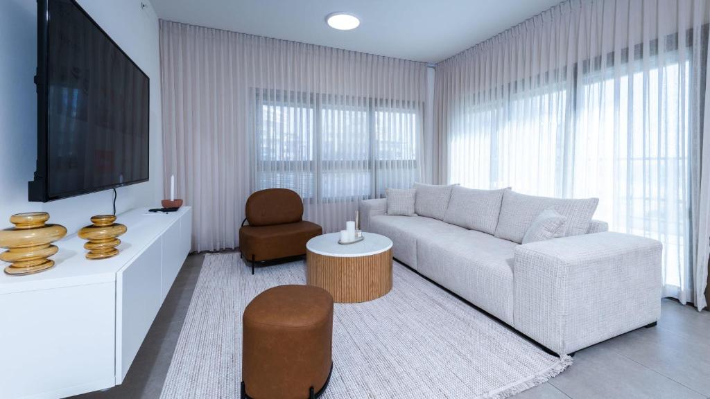 a living room with a white couch and a tv at O&O Group - SeaFront Luxurious 3 BR Apartment in Bat Yam