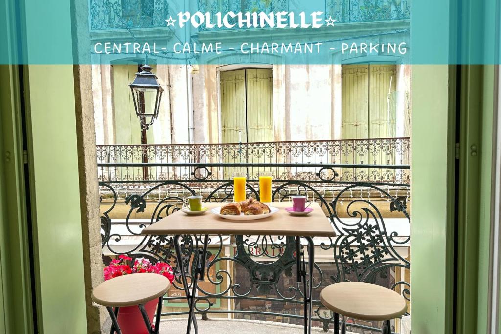 a table with a plate of food on a balcony at Polichinelle *Central *Charmant *Calme in Pézenas