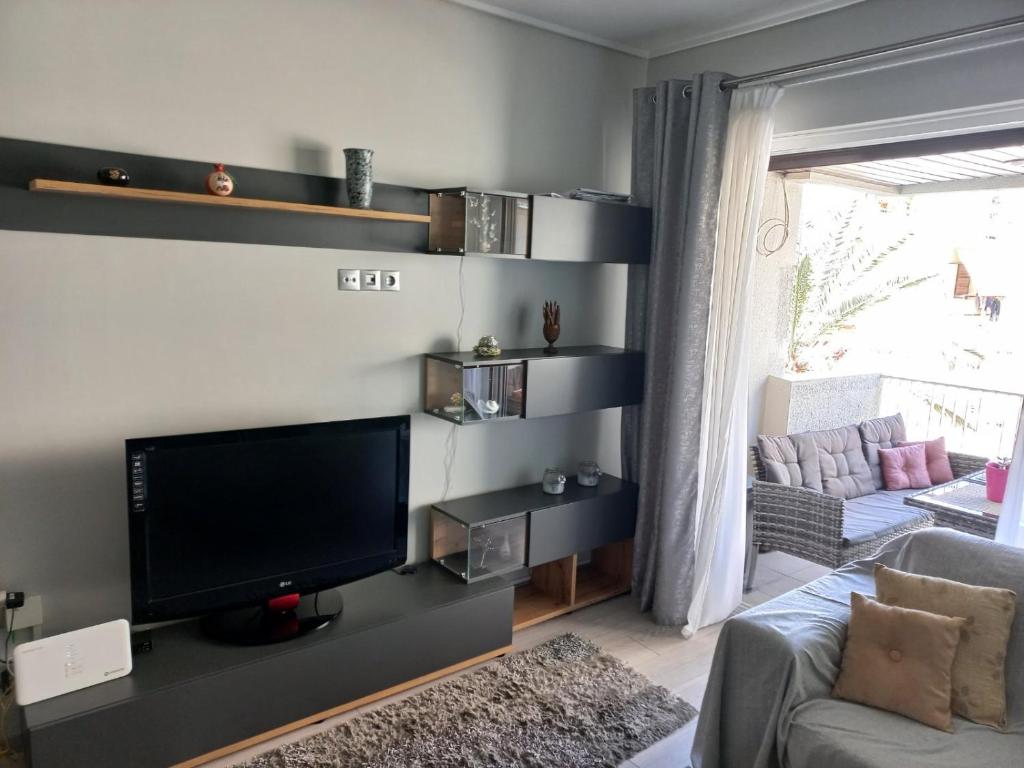 A television and/or entertainment centre at Lovely Faliro Apartment next to the sea.