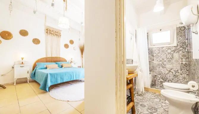 1 dormitorio con 1 cama y baño con lavamanos en Masseria li Vecchi en Squinzano