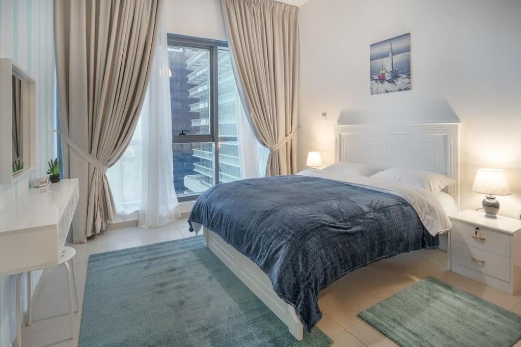 a bedroom with a bed and a large window at EXCELLENT 2 Bedroom Beach Front (Side View) in Abu Dhabi