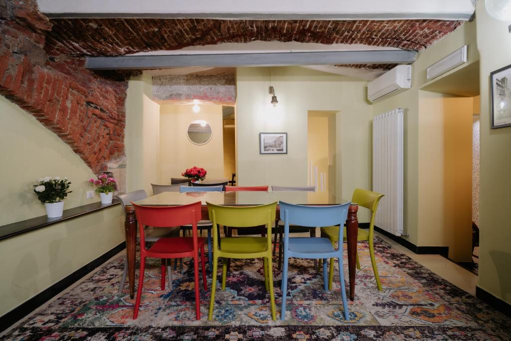 Habitación con mesa y sillas coloridas. en Le stanze del Piccadilly, en Génova