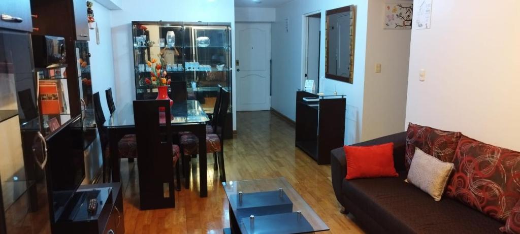 een woonkamer met een bank en een tafel bij Casa lelita in Lima