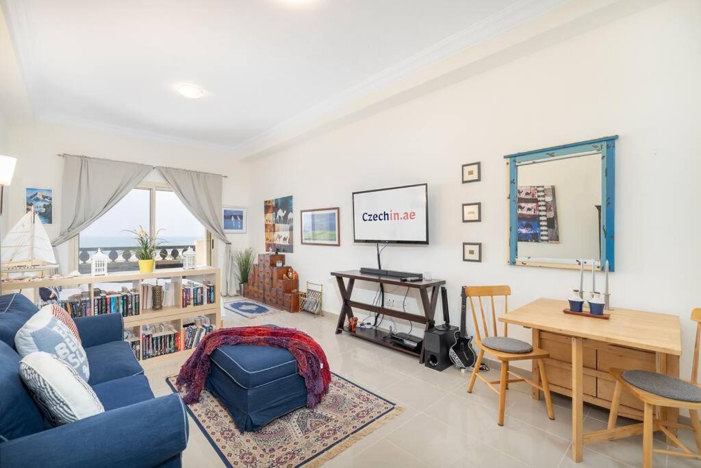 a living room with a blue couch and a table at Studio in Al Hamra Village with Sea View in Ras al Khaimah