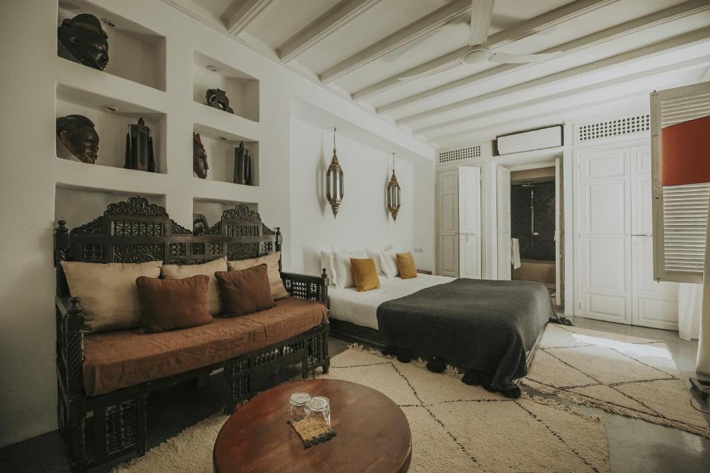 een slaapkamer met een bed en een bank bij Dar Zelda in Marrakesh