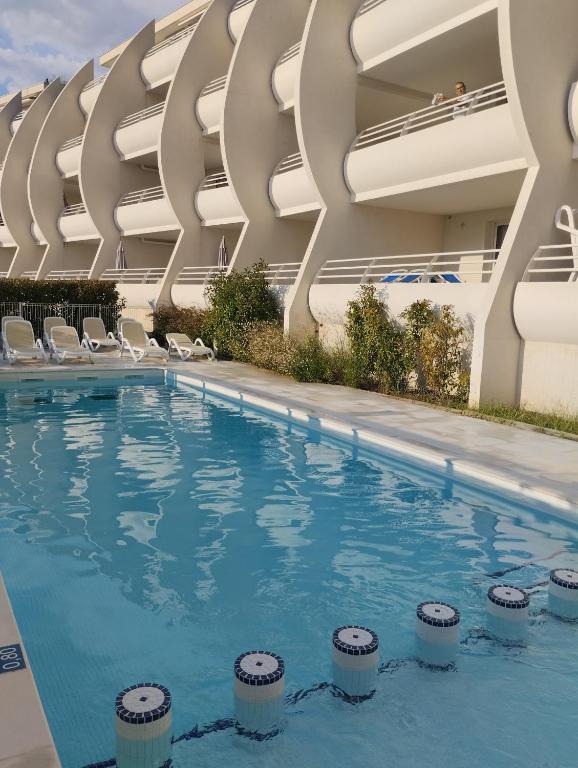 une piscine devant un immeuble dans l'établissement Les Dunes du Soleil, à La Grande Motte