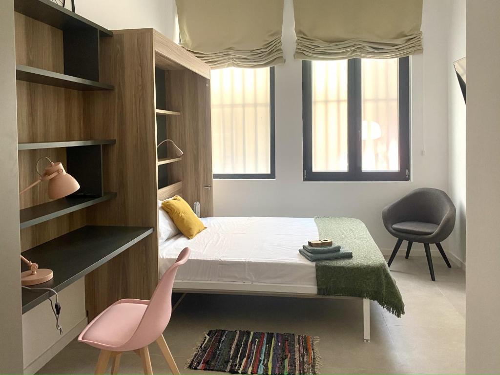 - une petite chambre avec un lit et deux chaises dans l'établissement Habitación en Playa Malvarrosa con baño privado -No AC-, à Valence