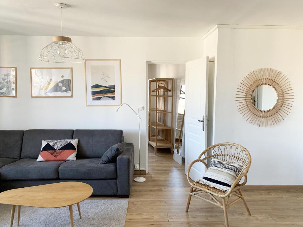 un salon avec un canapé bleu et une table dans l'établissement Appartement Cosy proche du centre, à Annecy