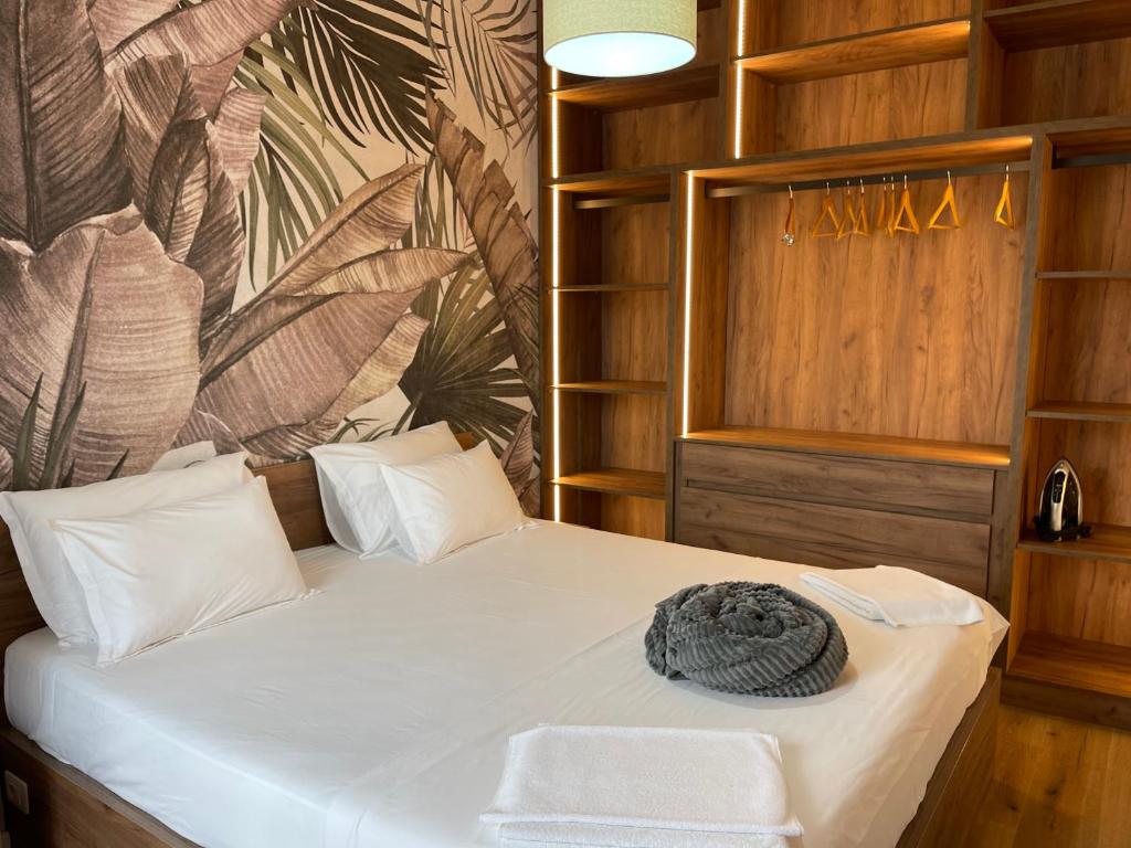1 dormitorio con 1 cama con sábanas blancas y paredes de madera en Erida’s Apartment, en Tirana