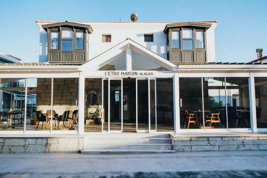 a building with glass doors and a restaurant at L'ETRO MAISON ALACATI HOTEL in Çeşme