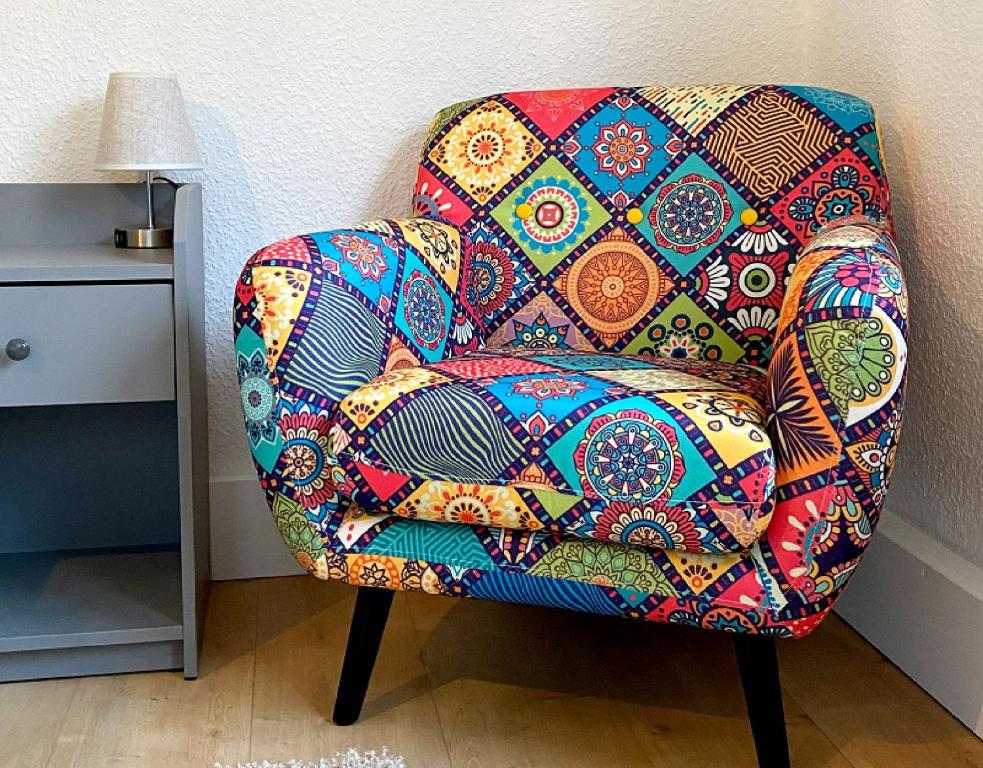a colorful chair sitting next to a wall at Ferienwohnung Fuldaufer in Melsungen