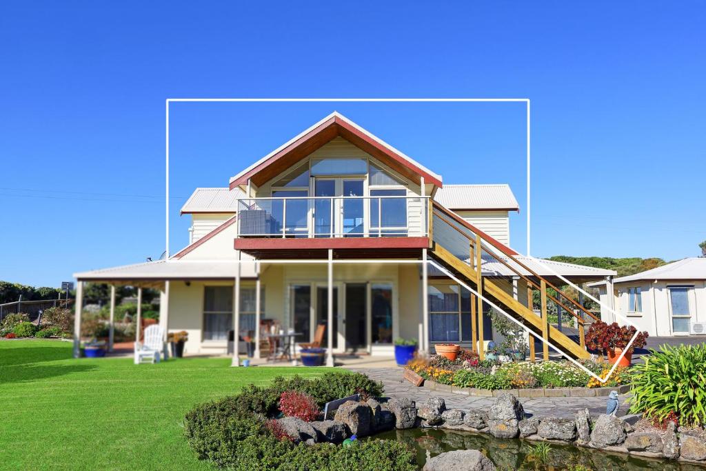 a large house with a porch and a yard at Logans Beach Whale Nursery Apartments - The Loft in Warrnambool