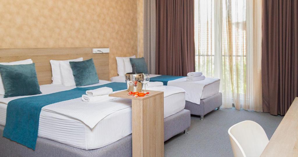 um quarto de hotel com duas camas e duas cadeiras em Garni Hotel Mint em Belgrado