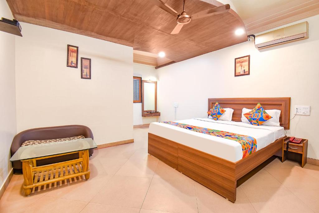 um quarto com uma cama e uma cadeira em FabHotel Shreeyash Residency em Pune