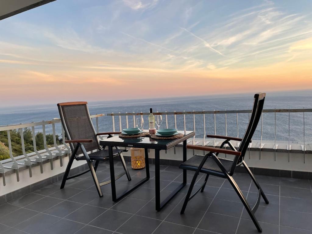 塞辛布拉的住宿－Sesimbra Balcony，阳台配有一张桌子和两把椅子,享有海景